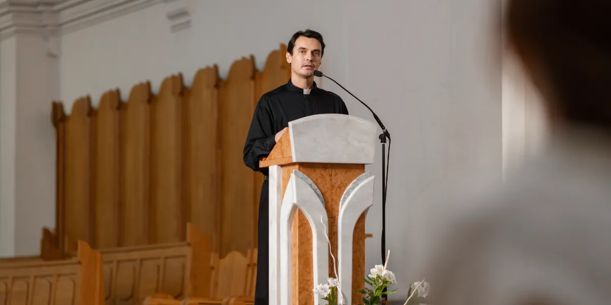 Man preaching from a pulpit in a modern church setting.